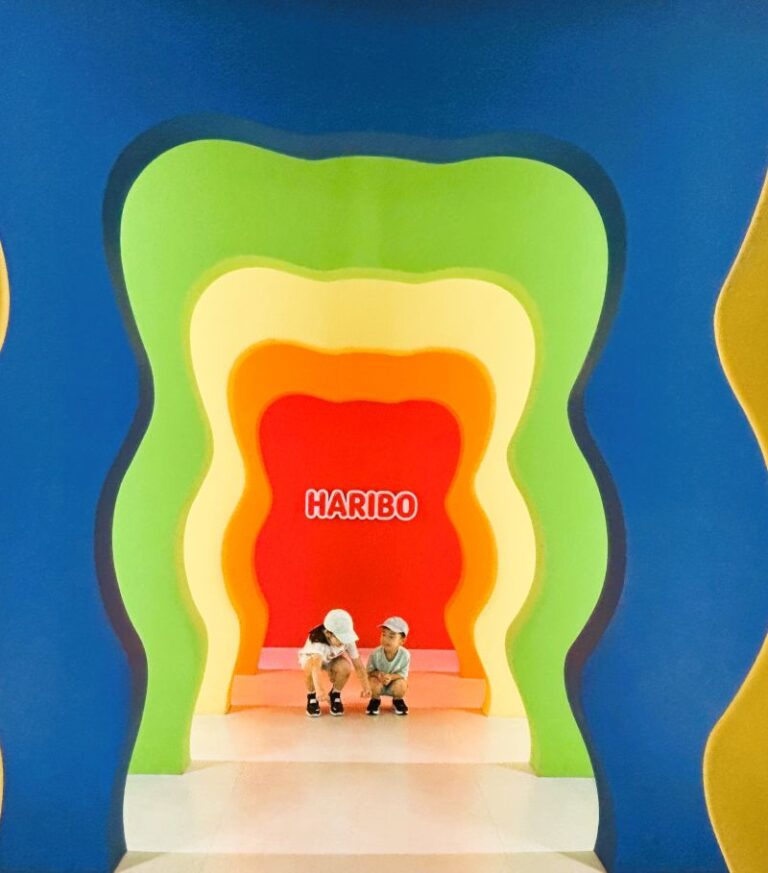 Kids posing in front of the HARIBO Happy World character